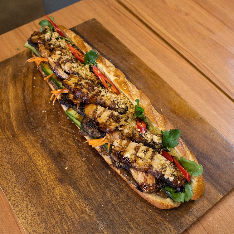 Suất bánh mỳ BBQ có phần bánh giòn rụm nóng hổi, bên trong có lớp pate dày cùng bơ béo ngậy. Tiếp đó là đồ chua, dưa chuột, hành lá, ớt tươi, rau mùi, dưa chuột, thị gà, ba chỉ lợn hun khói… (Ảnh: Third Wave Cafe)