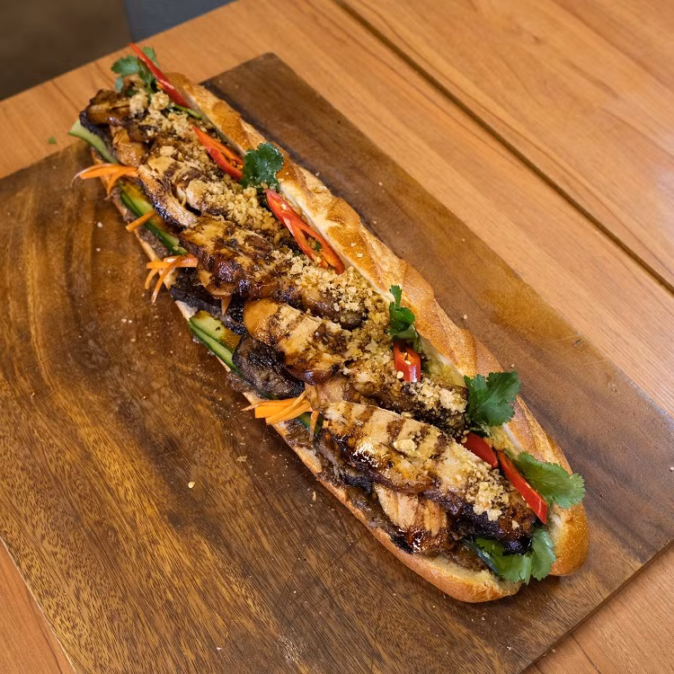 Suất bánh mỳ BBQ có phần bánh giòn rụm nóng hổi, bên trong có lớp pate dày cùng bơ béo ngậy. Tiếp đó là đồ chua, dưa chuột, hành lá, ớt tươi, rau mùi, dưa chuột, thị gà, ba chỉ lợn hun khói… (Ảnh: Third Wave Cafe)