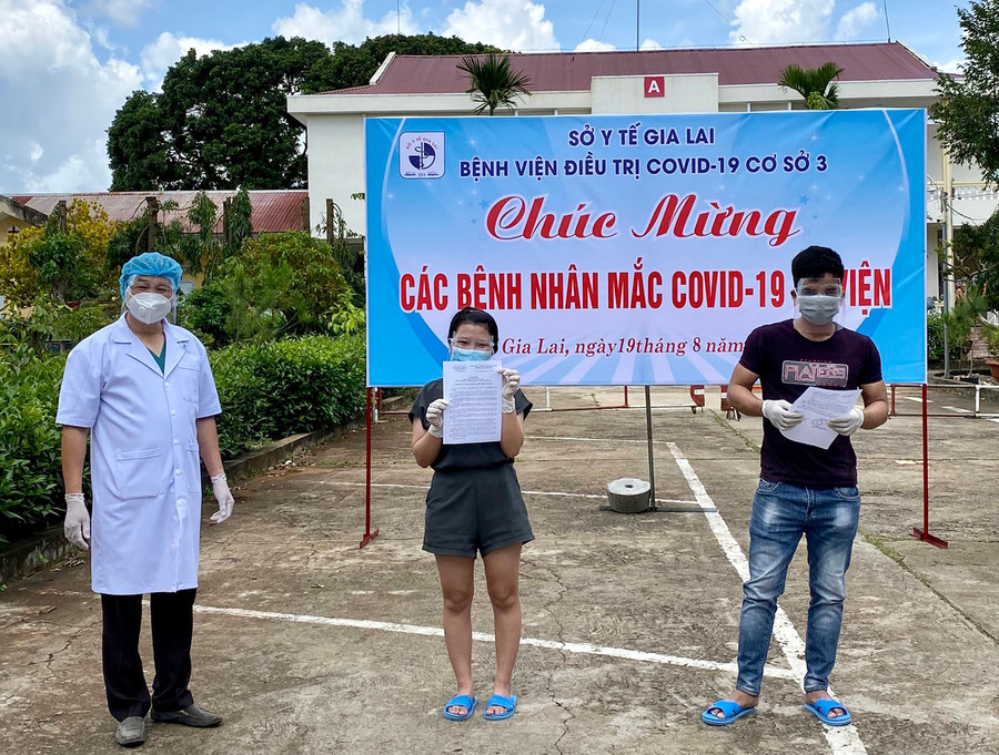 Nhân viên y tế trao giấy ra viện cho các công dân ngày 19-8-2021. Ảnh: Như Nguyện