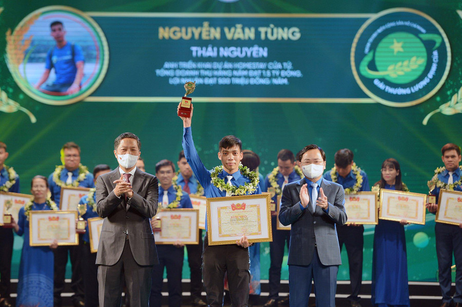 Ông Trần Tuấn Anh (bên trái) và anh Nguyễn Anh Tuấn (bên phải) trao giải thưởng cho các nông dân trẻ xuất sắc. Ảnh: Dương Triều
