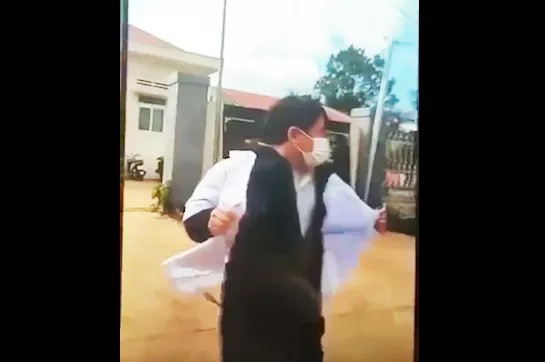 Ông Phạm Hồng Thái đến trước cổng Trạm Y tế xã Cư Né cởi áo để xé. Ảnh cắt từ clip.