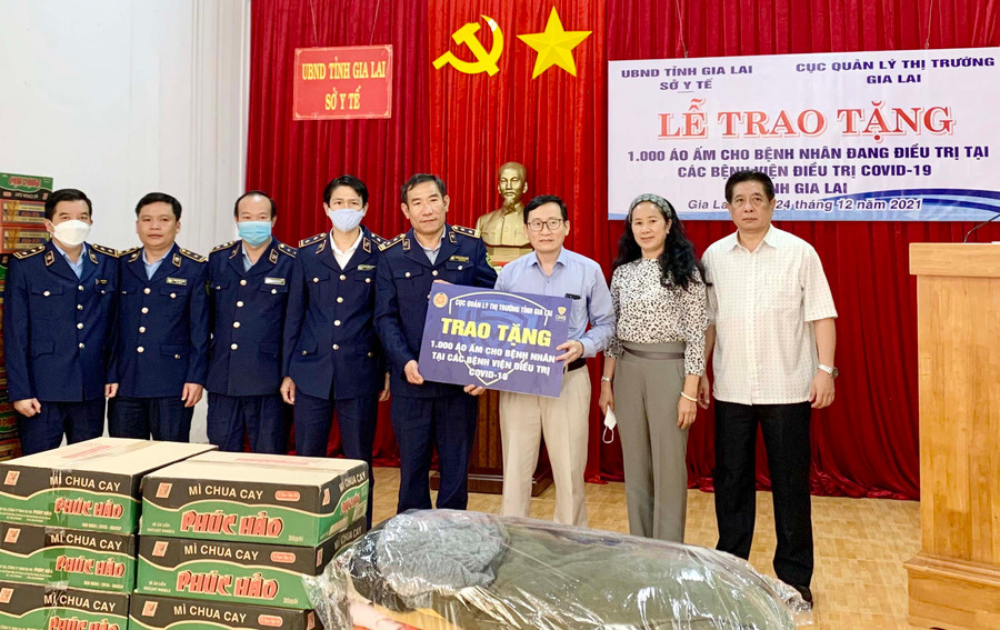 Đại diện Cục Quản lý Thị trường tỉnh Gia Lai trao bảng tượng trưng cho lãnh đạo Sở Y tế tỉnh. Ảnh: Như Nguyện