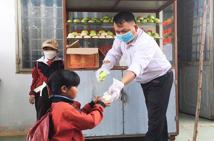 Thầy Vũ Văn Tùng phát bánh cho các em học sinh. Ảnh: Vũ Chi