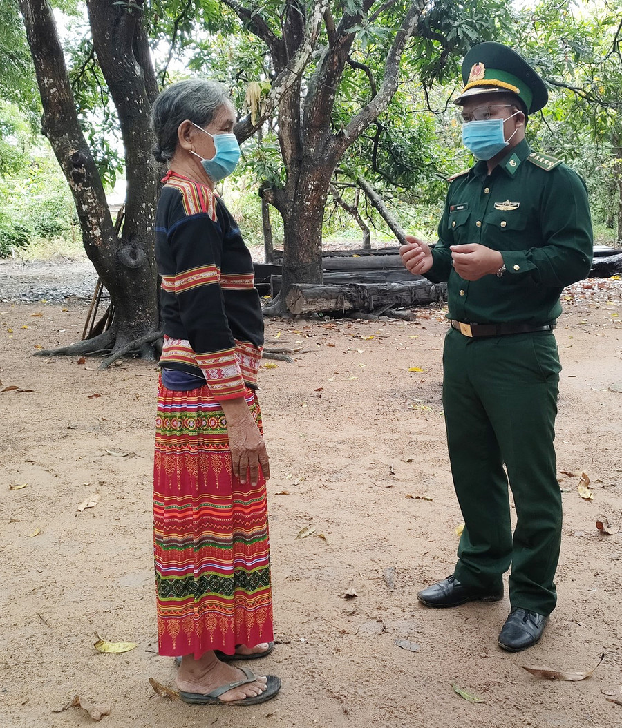 Đại úy Đinh Ơring-Chính trị viên phó Đồn Biên phòng Ia Mơr (huyện Chư Prông) trò chuyện cùng nữ già làng Ksor H'Blâm. Ảnh: Anh Huy