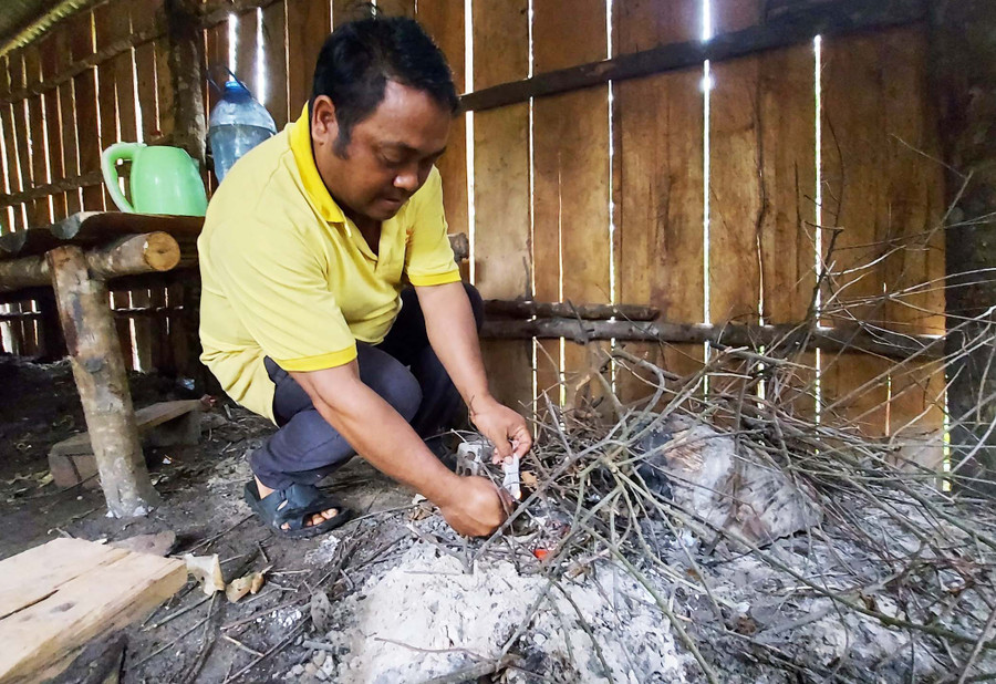 Đi gác rừng gặp trời mưa to và lạnh, anh Nal đốt lửa để sưởi ấm. Ảnh: Hoành Sơn