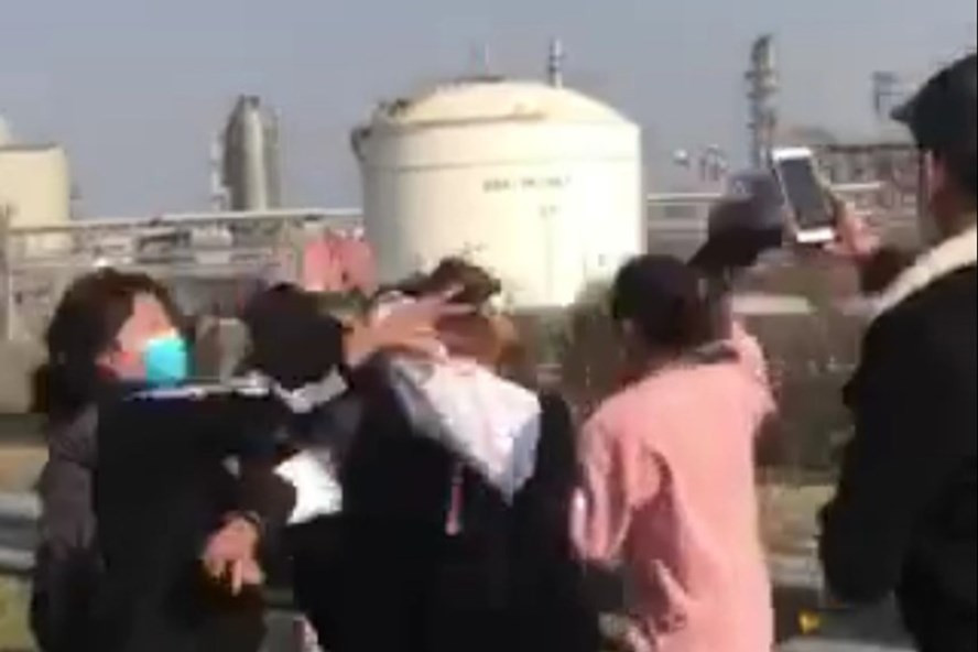 Nam sinh thản nhiên quay clip nhóm nữ sinh đánh hội đồng 2 thiếu nữ. Phía sau là nhà máy lọc dầu Nghi Sơn. Ảnh cắt từ clip