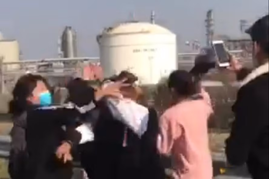 Nam sinh thản nhiên quay clip nhóm nữ sinh đánh hội đồng 2 thiếu nữ. Phía sau là nhà máy lọc dầu Nghi Sơn. Ảnh cắt từ clip