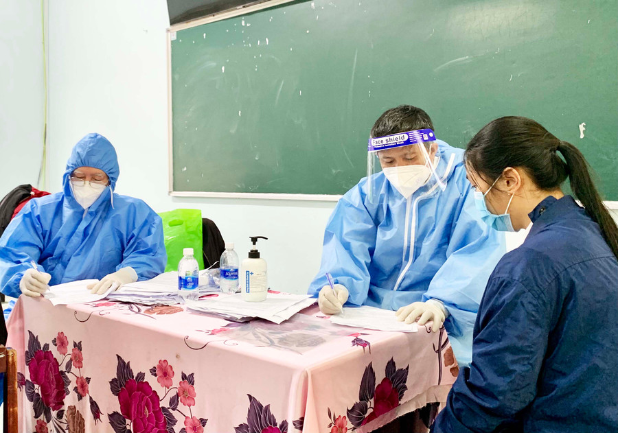 Nhân viên y tế khám sàng lọc trước khi tiêm vắc xin cho học sinh. Ảnh: Như Nguyện