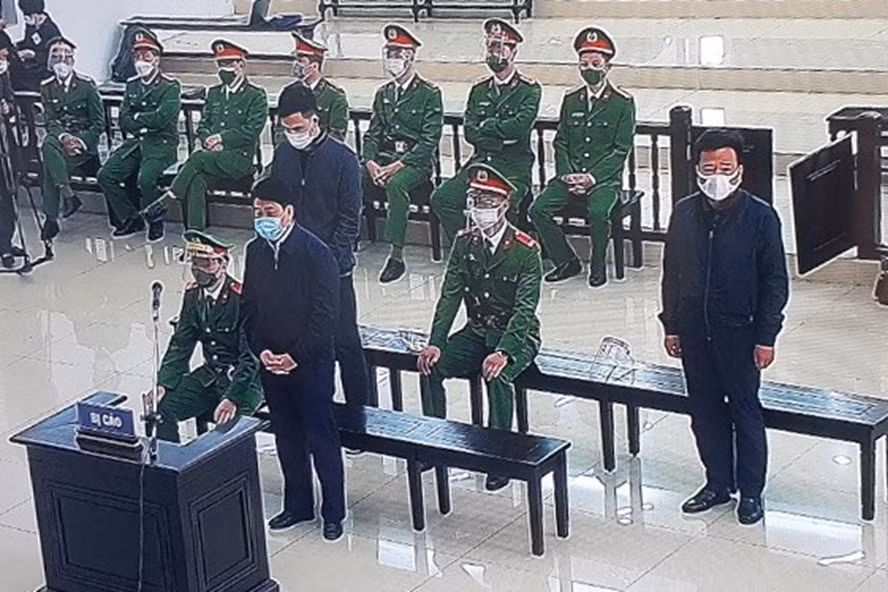 Ông Nguyễn Đức Chung (đứng đầu) cùng hai bị cáo nghe toà tuyên án. Ảnh chụp qua màn hình. Ông Nguyễn Đức Chung (đứng đầu) cùng hai bị cáo nghe toà tuyên án. Ảnh chụp qua màn hình.