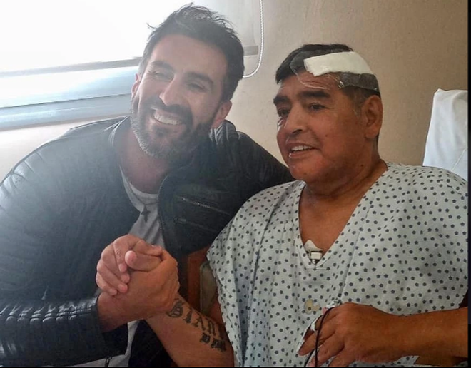 Diego Maradona và bác sĩ Leopoldo Luque sau cuộc phẫu thuật để loại bỏ cục máu đông trong não - Ảnh: Chụp màn hình Diego Maradona và bác sĩ Leopoldo Luque sau cuộc phẫu thuật để loại bỏ cục máu đông trong não - Ảnh: Chụp màn hình