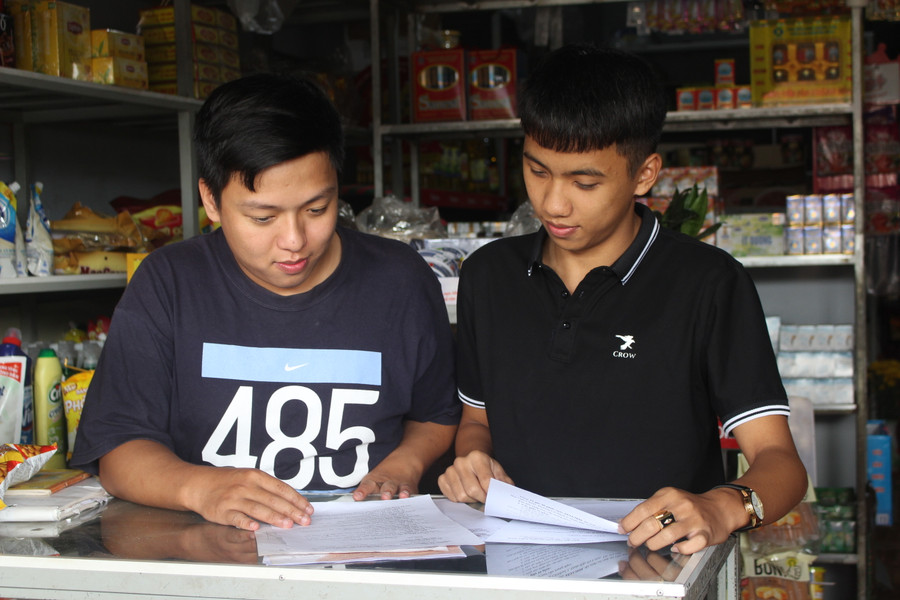 Em Trần Hoàng Vũ (bìa trái) và Nguyễn Trần Anh Duy-cựu học sinh Trường THPT Mạc Đĩnh Chi (huyện Chư Păh) kiểm tra lại hồ sơ nhập học Học viện Cảnh sát nhân dân. Ảnh: Thủy Bình