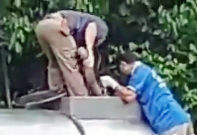 Lực lượng chức năng đưa thi thể hai vợ chồng ra khỏi bồn ẢNH CHỤP MÀN HÌNH.