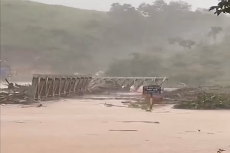  Cầu sắt Đăk Pne bị lũ cuốn, phải huy động ca nô chở gạo cứu đói cho người dân. Ảnh TA