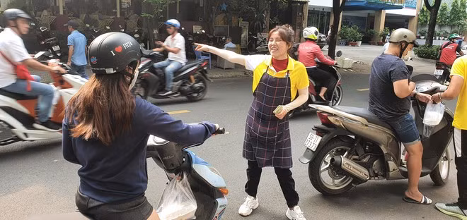 Gia Mỹ hoạt náo để thu hút khách đến mua xôi. ẢNH: TẤN ĐẠT