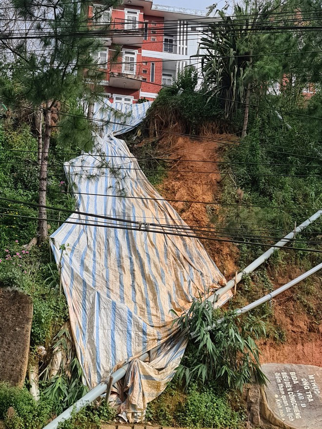 Cơ quan chức năng phải dùng bạt che tạm để chống sạt lở tại chung cư Khe Sanh - ẢNH: LÂM VIÊN