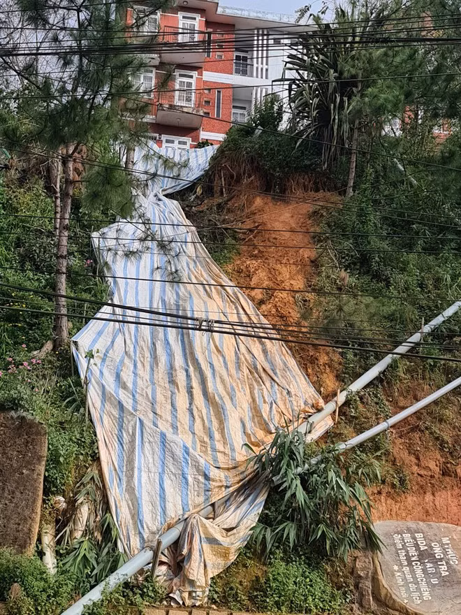 Cơ quan chức năng phải dùng bạt che tạm để chống sạt lở tại chung cư Khe Sanh - ẢNH: LÂM VIÊN