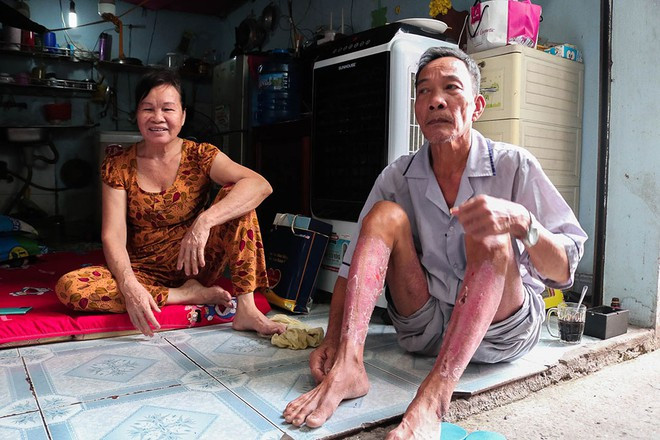 Vợ chồng ông Công ngồi trước căn trọ của con trai.