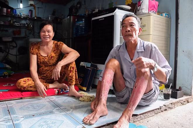 Vợ chồng ông Công ngồi trước căn trọ của con trai.