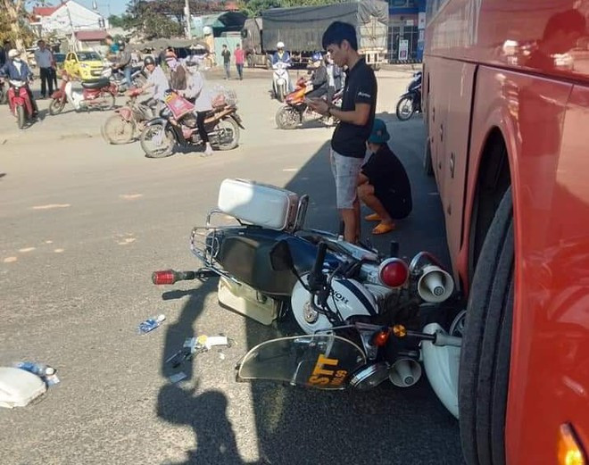 Xe mô tô chuyên dụng của Cảnh sát trật tự kẹt dưới bánh xe trước phía phụ xe khách ẢNH: C.T.V