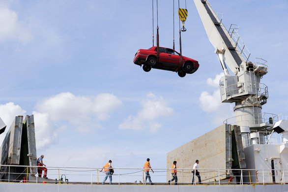 Một chiếc xe hơi đã qua sử dụng được đưa lên tàu ở Hamburg, Đức để xuất khẩu - Ảnh: New York Times/Alamy Một chiếc xe hơi đã qua sử dụng được đưa lên tàu ở Hamburg, Đức để xuất khẩu - Ảnh: New York Times/Alamy