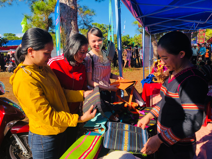 Người dân mua sản phẩm của Hợp tác xã Dệt thổ cẩm xã Glar. Ảnh: Phan Lài