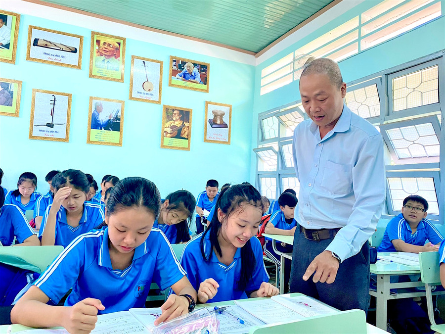 Thầy Nguyễn Đức Lộc hướng dẫn học sinh đọc nốt nhạc. Ảnh: Hồng Thi