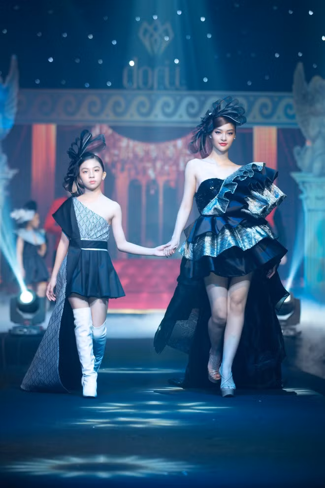 Á hậu Kiều Loan xuất hiện trên sàn catwalk cùng với người mẫu nhí Nguyệt Nhật Ánh Minh. Người đẹp như một quý cô thành thị trong thiết kế đầm lệch vai gợi cảm màu đen. Gần đây, Kiều Loan gây chú ý với khán giả khi tham gia chương trình King of Rap. Từng gây tranh cãi ở những vòng đầu tiên nhưng người đẹp sinh năm 2000 dần thuyết phục khán giả bằng sự tiến bộ của mình qua từng vòng thi. Dù bị loại, Kiều Loan vẫn cảm thấy hài lòng với hành trình của bản thân tại sân chơi này. ẢNH: NGUYỄN XUÂN HUY