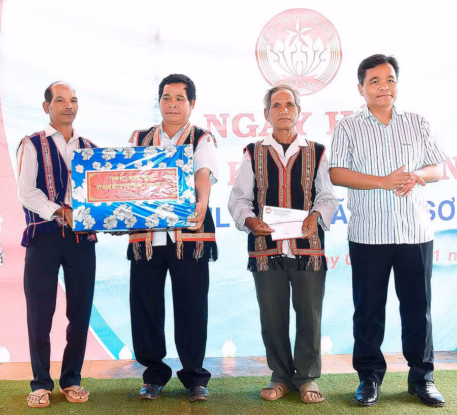 Bí thư Tỉnh ủy Hồ Văn Niên (bìa phải) tặng quà cho cán bộ và nhân dân làng Tul Đoa (xã Đak Sơ Mei, huyện Đak Đoa). Ảnh: Đức Thụy