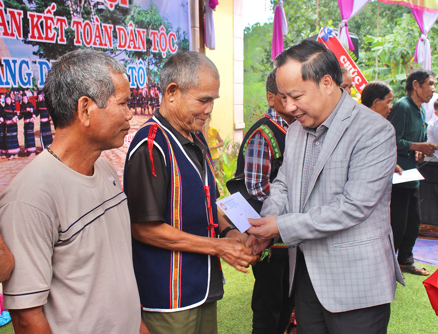  Đồng chí Châu Ngọc Tuấn-Phó Bí thư Thường trực Tỉnh ủy tặng quà cho các hộ gia đình khó khăn của làng Del. Ảnh: Phan Lài