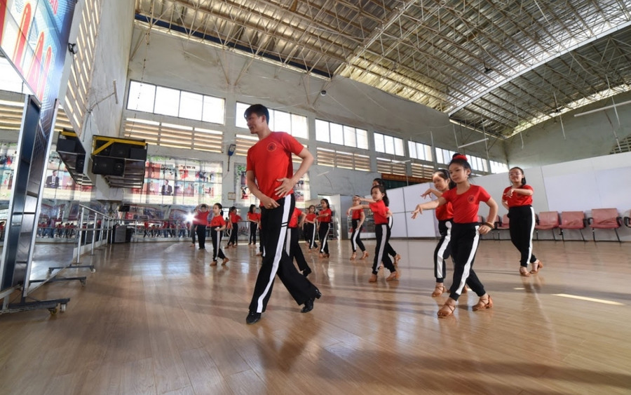 “Bệ phóng” cho tài năng khiêu vũ thể thao (GLO)- Sau hơn 2 năm thành lập, Câu lạc bộ (CLB) Khiêu vũ thể thao Dream Dance Gia Lai thuộc Trung tâm Huấn luyện và Thi đấu thể thao tỉnh đã góp phần không nhỏ trong việc ươm mầm tài năng, thúc đẩy phong trào tập luyện môn khiêu vũ thể thao (Dancesport) ngày càng phát triển. Ươm mầm tài năng Câu lạc bộ Khiêu vũ thể thao Dream Dance Gia Lai được thành lập vào tháng 10-2018, do huấn luyện viên Trần Nam Dũng làm Chủ nhiệm. Anh Dũng cho biết: “Năm 2010, tôi mở lớp dạy khiêu vũ thể thao tại Nhà Thiếu nhi tỉnh với khoảng 15 học viên. Sau khi thành lập CLB, tôi chuyển về Trung tâm Huấn luyện và Thi đấu thể thao tỉnh, tiếp tục chiêu sinh. Hiện CLB có 10 em toàn năng thi đấu 10 điệu thành tích cao”. Sau hơn 2 năm thành lập, CLB đã đào tạo được nhiều vận động viên (VĐV) tài năng, góp phần nâng cao vị thế của Gia Lai trong làng khiêu vũ thể thao cả nước. Một số gương mặt sáng giá trưởng thành từ CLB như: Trần Nguyễn Hoàng Diệu (14 tuổi), Đào Diễm Quyên (16 tuổi), Lê Phương Thảo (13 tuổi), La Gia Hân (12 tuổi)… thường xuyên mang về cho tỉnh nhà nhiều huy chương các loại khi tranh tài ở các giải khu vực, toàn quốc. Em Trần Nguyễn Hoàng Diệu bộc bạch: “Ban đầu, em đi học môn này để rèn luyện sức khỏe, nhưng sau đam mê nên tập luyện chăm chỉ. Nhờ huấn luyện viên chỉ bảo tận tình nên em tiếp thu bài dạy nhanh, nhảy càng ngày càng tốt hơn. Em sẽ cố gắng hơn nữa để trở thành VĐV giỏi môn này”. Theo thống kê, từ năm 2018 đến nay, các VĐV của CLB Khiêu vũ thể thao Dream Dance Gia Lai được Sở Văn hóa-Thể thao và Du lịch tuyển chọn tham dự hơn 30 giải khiêu vũ thể thao trong nước lẫn quốc tế. Tại các giải đấu, VĐV Gia Lai thi đấu ngang ngửa với các đối thủ của một số đơn vị mạnh như: Hà Nội, Hải Phòng, Đà Nẵng, TP. Hồ Chí Minh. Điển hình như tại Giải vô địch Khiêu vũ thể thao Đà Nẵng mở rộng lần thứ V năm 2020 với sự tham gia của 600 VĐV thuộc 38 đoàn trong cả nước, đoàn Gia Lai gồm 12 VĐV đã xuất sắc giành vị trí nhất toàn đoàn. Đây là giải đấu thành công nhất của các VĐV thuộc CLB Khiêu vũ thể thao Dream Dance Gia Lai khi giành được 23 huy chương vàng, 16 huy chương bạc, 5 huy chương đồng. Trước đó, năm 2019, tại một giải khiêu vũ thể thao quốc tế tổ chức ở Singapore, 2 nữ VĐV của CLB đã lọt vào bán kết ở nội dung đơn nữ điệu Jive. Bên cạnh việc đào tạo chuyên sâu, CLB Khiêu vũ thể thao Dream Dance Gia Lai còn tổ chức dạy thêm cho các học viên ở mọi lứa tuổi và hỗ trợ các địa phương phát triển môn thể thao này. Hiện nay, ngoài 70 VĐV đang tập luyện tại Trung tâm Huấn luyện và Thi đấu thể thao tỉnh còn có 400 học viên ở 7 cơ sở dạy khiêu vũ thể thao khác ở các huyện của tỉnh Kon Tum và Gia Lai được huấn luyện viên Trần Nam Dũng cùng các thành viên CLB hướng dẫn thêm về chuyên môn. Đặt mục tiêu cao ở giải đấu trên sân nhà Theo kế hoạch của Sở Văn hóa-Thể thao và Du lịch, ngày 12-12, tại Nhà Thi đấu thể thao tỉnh sẽ diễn ra Giải vô địch Khiêu vũ thể thao Gia Lai mở rộng lần thứ III năm 2020. Giải đấu dự kiến quy tụ khoảng 30 đoàn với hơn 400 VĐV trong cả nước thi đấu ở 367 nội dung. Đây là giải có quy mô lớn nhất từ trước tới nay tại Gia Lai với sự tham gia của nhiều đơn vị mạnh về bộ môn này như: Hà Nội, Hải Phòng, Đà Nẵng và TP. Hồ Chí Minh. Chủ nhiệm CLB Khiêu vũ thể thao Dream Dance Gia Lai cho hay: “Tại giải này, CLB sẽ cử 250 VĐV thành tích cao và phong trào tham gia thi đấu ở 200 nội dung. Chúng tôi không đặt mục tiêu ở nội dung toàn đoàn nhưng cố gắng giành được nhiều giải thưởng cao ở các nội dung khác. Tới đây, chúng tôi sẽ mời những huấn luyện viên giỏi để hướng dẫn thêm kỹ năng cho VĐV của CLB và các cơ sở”. Trước thềm giải đấu trên sân nhà, các VĐV của CLB Khiêu vũ thể thao Dream Dance Gia Lai nỗ lực tập luyện với mục tiêu giành giải cao nhất. Trong đó, các VĐV thi đấu 10 điệu thành tích cao đang là những người tập luyện tích cực nhất. “Giai đoạn này, em tập luyện nhiều hơn để nhuần nhuyễn các bài thi, điệu nhảy. Ngoài tập 3 buổi tại trung tâm, em còn tập thêm ở nhà lúc rảnh rỗi. Em cũng lên mạng internet học hỏi thêm để nâng cao trình độ”-VĐV Lê Phương Thảo chia sẻ. Ông Nguyễn Văn Ý-Giám đốc Trung tâm Huấn luyện và Thi đấu thể thao tỉnh: “Dù mới thành lập nhưng CLB Khiêu vũ thể thao Dream Dance Gia Lai có những bước tiến đáng ghi nhận. Các VĐV của CLB có trình độ chuyên môn tốt và đạt nhiều giải cao tại các giải đấu khu vực, toàn quốc. Câu lạc bộ cũng góp công không nhỏ trong việc thúc đẩy phong trào tập luyện môn khiêu vũ thể thao trên địa bàn tỉnh”. THIÊN DI Huấn luyện viên Trần Nam Dũng hướng dẫn học viên tập luyện. Ảnh: Thiên Di