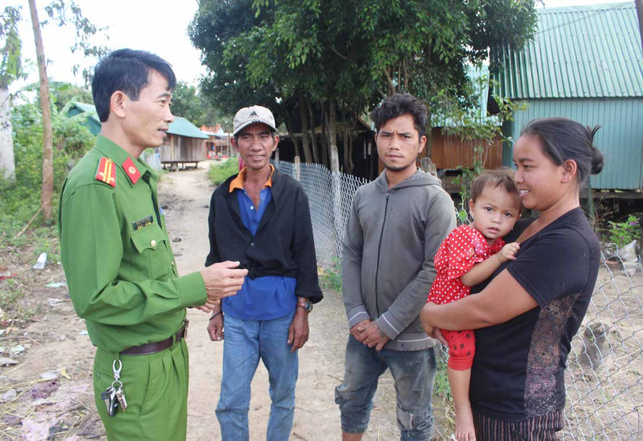 Trung tá Trần Văn Hùng (bìa trái)-Trưởng công an xã Đak Jơ Ta tuyên truyền người dân tuân thủ các quy định của pháp luật. Ảnh: Phan Lài