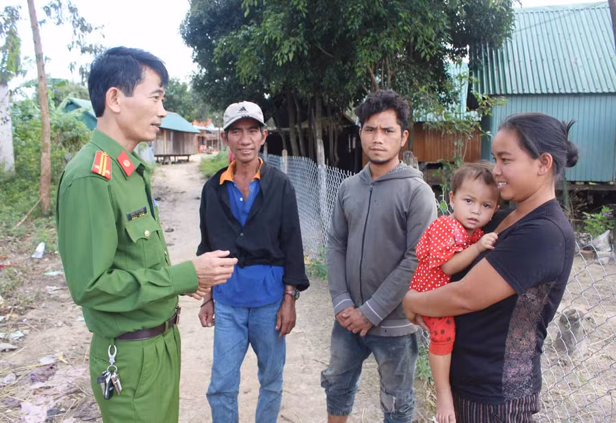 Trung tá Trần Văn Hùng (bìa trái)-Trưởng công an xã Đak Jơ Ta tuyên truyền người dân tuân thủ các quy định của pháp luật. Ảnh: Phan Lài