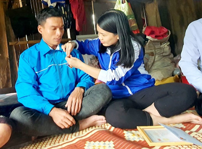 Chị Trần Thị Thu, Bí thư Tỉnh đoàn Quảng Trị đeo huy hiệu Tuổi trẻ dũng cảm cho Hồ Văn Xuôn ẢNH: THANH LỘC
