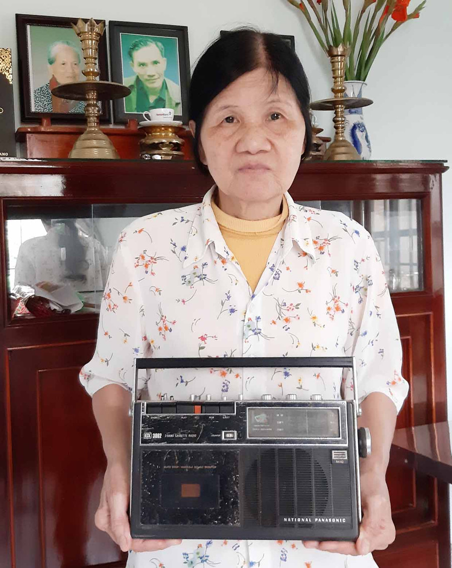 Bà Trần Thị Hòa và chiếc máy phát băng cũ trước bàn thờ ba má. Ảnh: Nguyễn Quang Tuệ