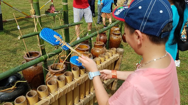 Khách tham quan còn có cơ hội trải nghiệm tơ rưng thấp, đây là một trải nghiệm đặc biệt hấp dẫn với các em nhỏ. (Ảnh: Minh Anh/Vietnam+)