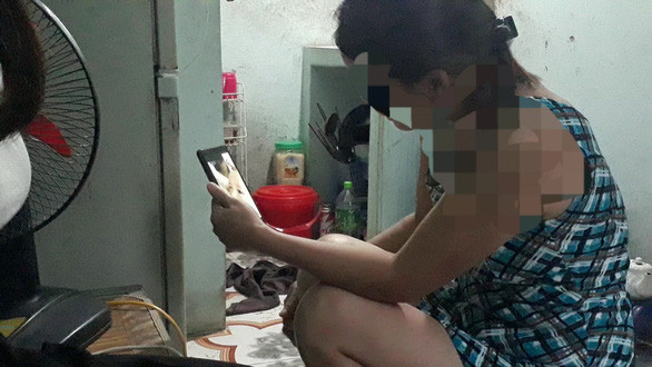 Chị Bùi Thị Vy gọi video về cho con mỗi ngày để đỡ nhớ - Ảnh: TÂM LÊ