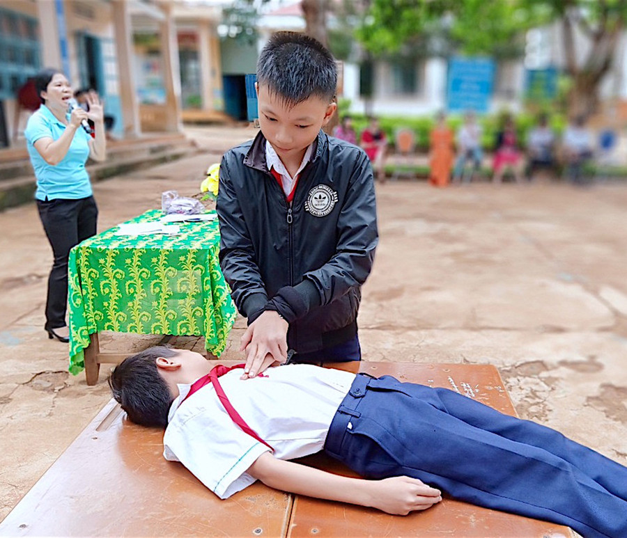 Học sinh Trường Tiểu học Kim Đồng (huyện Đức Cơ) thực hành kỹ năng sơ cứu cho người bị đuối nước trong giờ chào cờ. Ảnh: Mộc Trà