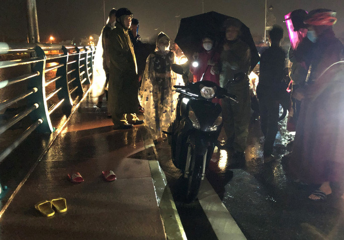 Chiếc xe máy cùng hai đôi dép nghi ngờ do người phụ nữ ôm hai con nhảy cầu để lại. Ảnh: T.Trực Chiếc xe máy cùng hai đôi dép nghi ngờ do người phụ nữ ôm hai con nhảy cầu để lại. Ảnh: T.Trực