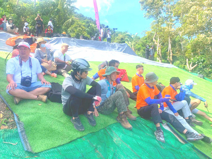  Các phi công ngồi trên đỉnh Phụng Hoàng Sơn chờ gió nhẹ để buông mình đáp xuống sân đua bò