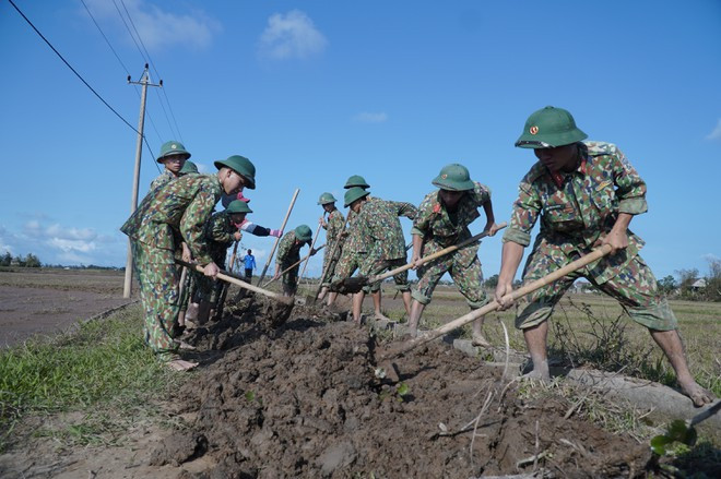 Lực lượng thanh niên quân đội tham gia dọn bùn tại xã Triệu Giang (H.Triệu Phong, Quảng Trị) ẢNH: NGUYỄN PHÚC