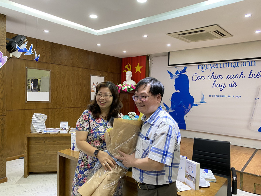  Bà Phan Thị Thu Hà - Phó giám đốc phụ trách NXB Trẻ tặng hoa cho nhà văn Nguyễn Nhật Ánh tại buổi ra mắt sách Con chim xanh biếc bay về. Ảnh: Như Thuần