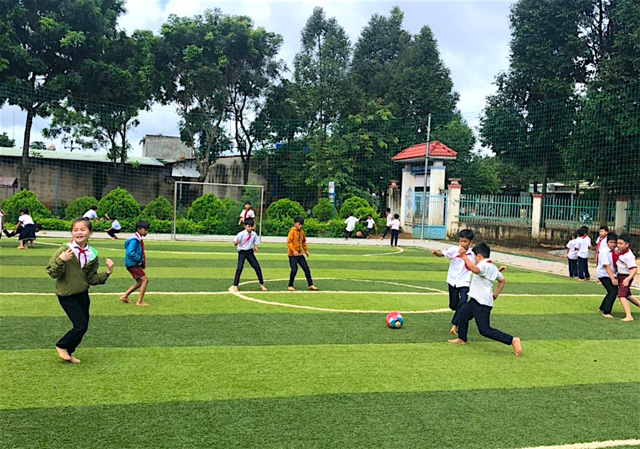 Học sinh Trường Tiểu học Nguyễn Bá Ngọc (xã Ia O, huyện Ia Grai) đá bóng trên sân mini cỏ nhân tạo do nhà trường đầu tư xây dựng từ nguồn xã hội hóa. Ảnh Hồng Thi