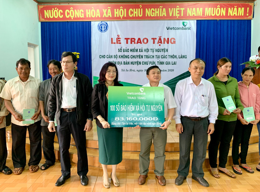 Bà Đỗ Thị Việt Hằng-Giám đốc Ngân hàng Vietcombank chi nhánh Gia Lai trao bảng tượng trưng tặng sổ BHXH tự nguyện cho đại diện UBND huyện Chư Pưh. Ảnh: Như Nguyện