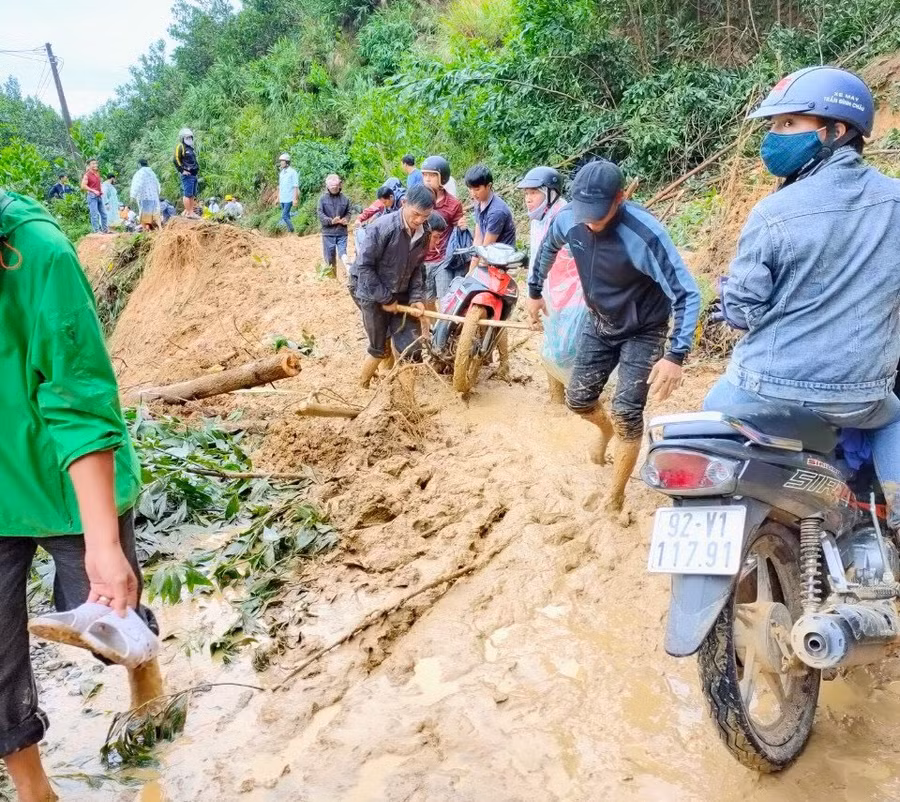 Các giáo viên thường xuyên lội bùn, khiên xe máy qua các điểm sạt lở. Ảnh: Kim Thoa