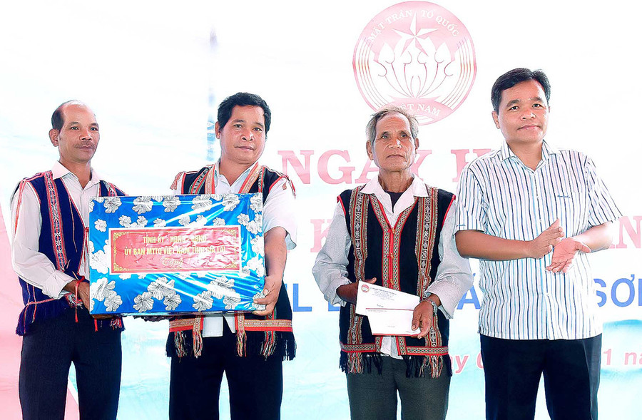 Đồng chí Hồ Văn Niên (bìa phải)-Ủy viên dự khuyết Ban Chấp hành Trung ương Đảng, Bí thư Tỉnh ủy, Trưởng đoàn đại biểu Quốc hội tỉnh tặng quà cho bà con làng Tul Đoa, xã Đak Sơ Mei, huyện Đak Đoa tại Ngày hội Đại đoàn kết toàn dân tộc. Ảnh: Đức Thụy