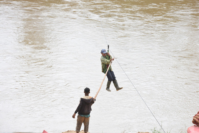 Một người đu cáp treo bị mắc kẹt, phải nhờ người khác hỗ trợ kéo vào bờ Một người đu cáp treo bị mắc kẹt, phải nhờ người khác hỗ trợ kéo vào bờ