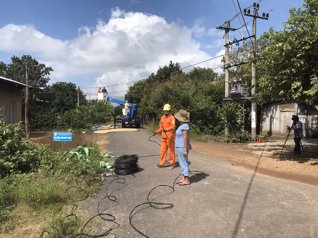 Người dân buôn Đrang Phốk phấn khởi trò chuyện với nhân viên Công ty Điện lực Đắk Lắk