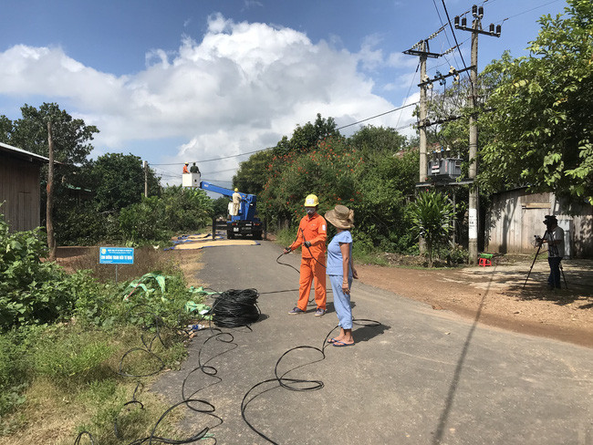 Người dân buôn Đrang Phốk phấn khởi trò chuyện với nhân viên Công ty Điện lực Đắk Lắk