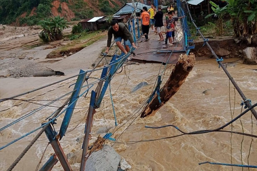 Một cây cầu treo ở xã Phước Thành bị nước lũ đanh tan.