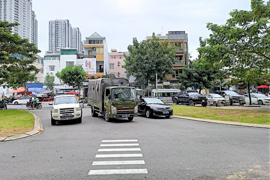 Xe của lực lượng chức năng đến khám nghiệm hiện trường vụ thi thể người phụ nữ bị đứt lìa đầu tại một chung cư nằm tại phường Tân Hưng, quận 7. Ảnh: Kỳ Hoa